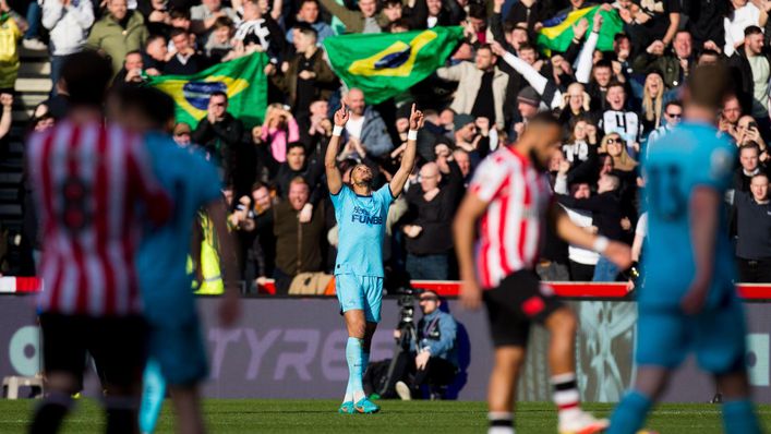 Joelinton celebrates in front of a Newcastle away end filled with Brazilian flags