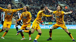 Cambridge United players celebrate in jubilation following their goal