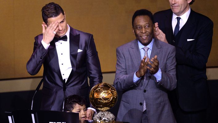 Cristiano Ronaldo wipes away the tears after Pele (right) presented him with the trophy