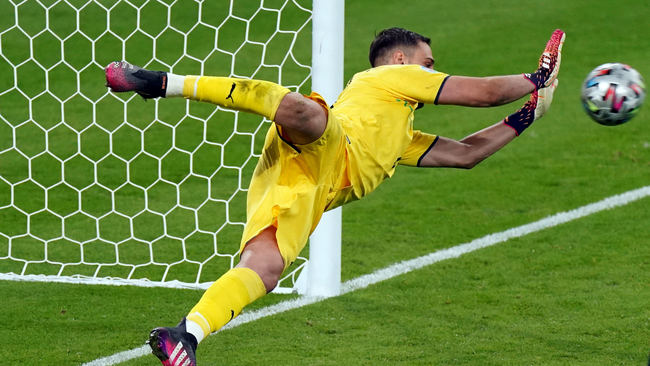 Gianluigi Donnarumma is at full stretch to make a save in the shootout